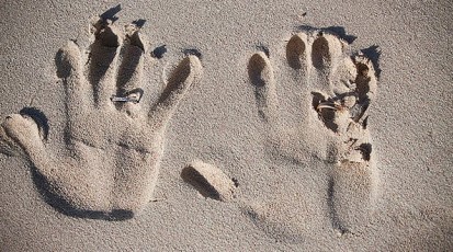 wedding rings with handprints in the sand