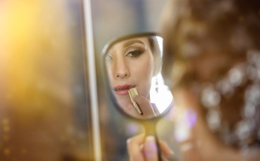 Bride looking at the mirror during the makeup process