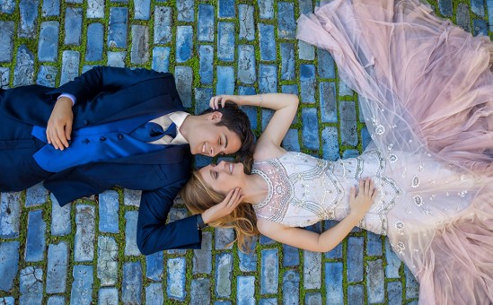 Wedding couple lying on cobblestone street in Old San Juan